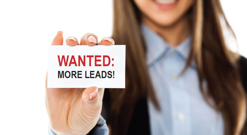 businesswoman holding "wanted: more leads" card