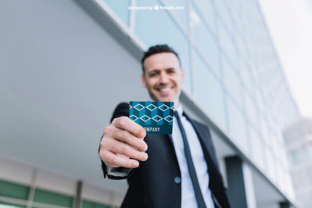 businessman smiling and holding out business card