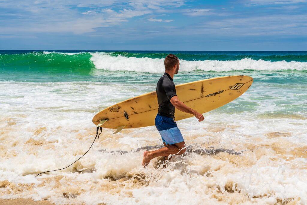 Man with surfboard on beach Australia