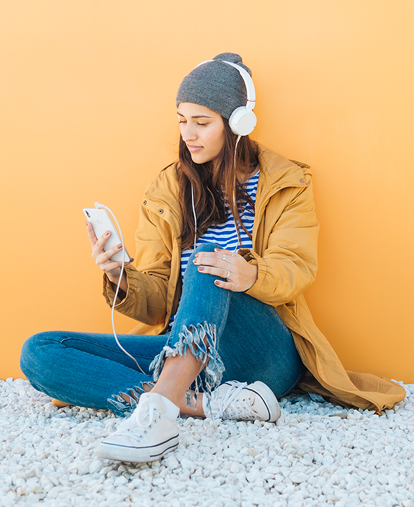 Young woman listening to music on cell phone